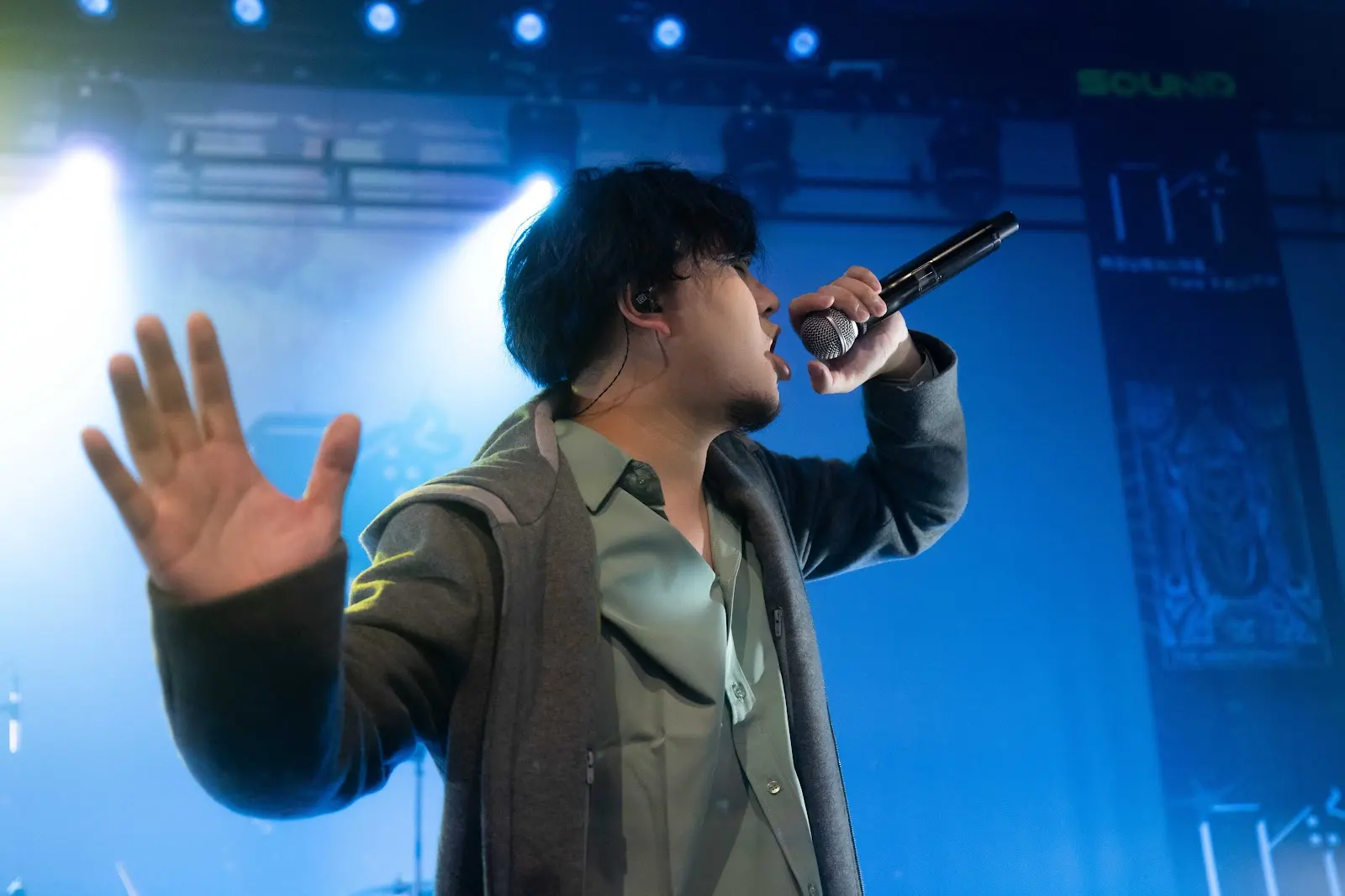 Rex Wong performing on stage with microphone